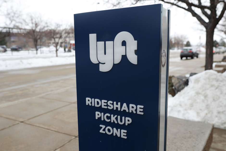  A sign for the car sharing service Lyft stands near a pickup zone outside the Pepsi Center in downtown Denver. (AP)