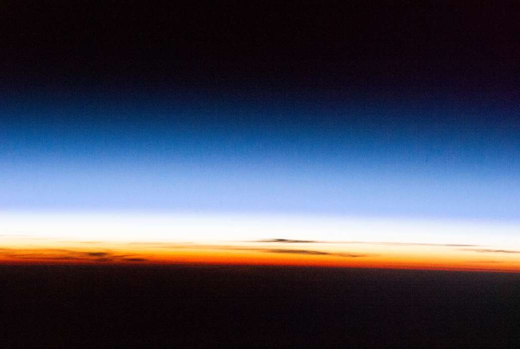 An image of the atmosphere from the International Space Station. The colors roughly align with different layers of the atmosphere — the orange troposphere, the white stratosphere and the blue mesosphere. (Chris Hadfield)