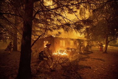 Firefighters work to keep flames from spreading through an apartment complex in Paradise, Calif. (AP Photo/Noah Berger)