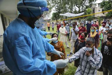 People line up to give their swab samples to test for COVID-19 in Jammu, India. Scientists have developed a new test that can give reliable results within seconds. (AP Photo/Channi Anand)