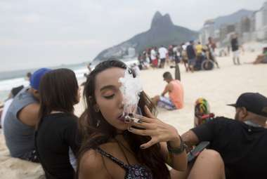 A woman smokes a marijuana joint on Ipanema beach, in Rio de Janeiro, Brazil. New research shows that cannabis use affects women’s sleep more than men’s. (AP Photo/Silvia Izquierdo)